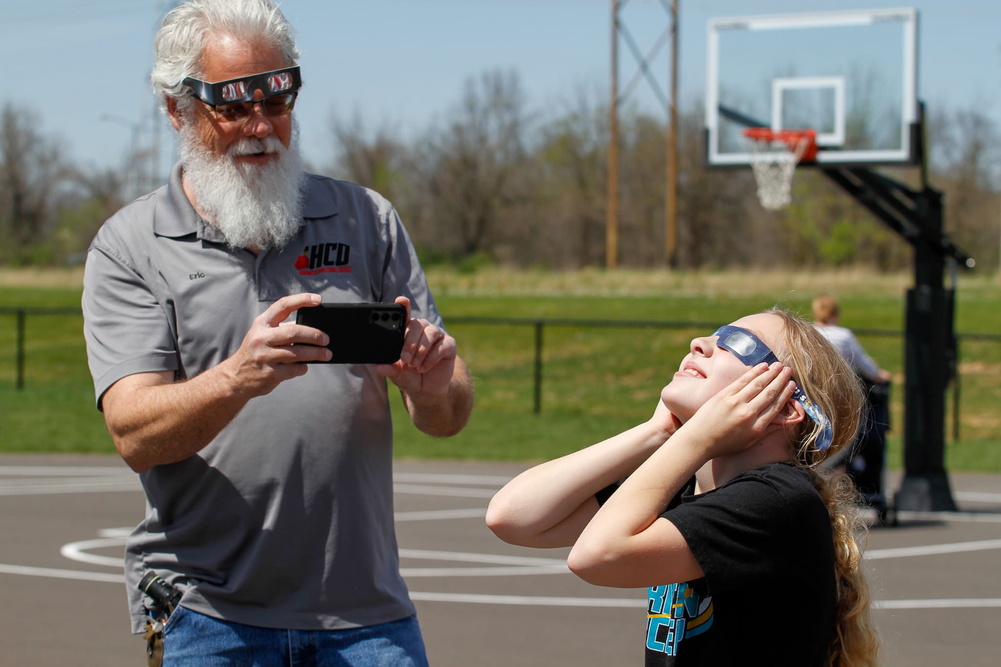 A father takes a photo of his daughter enjoying the Solar Eclipse